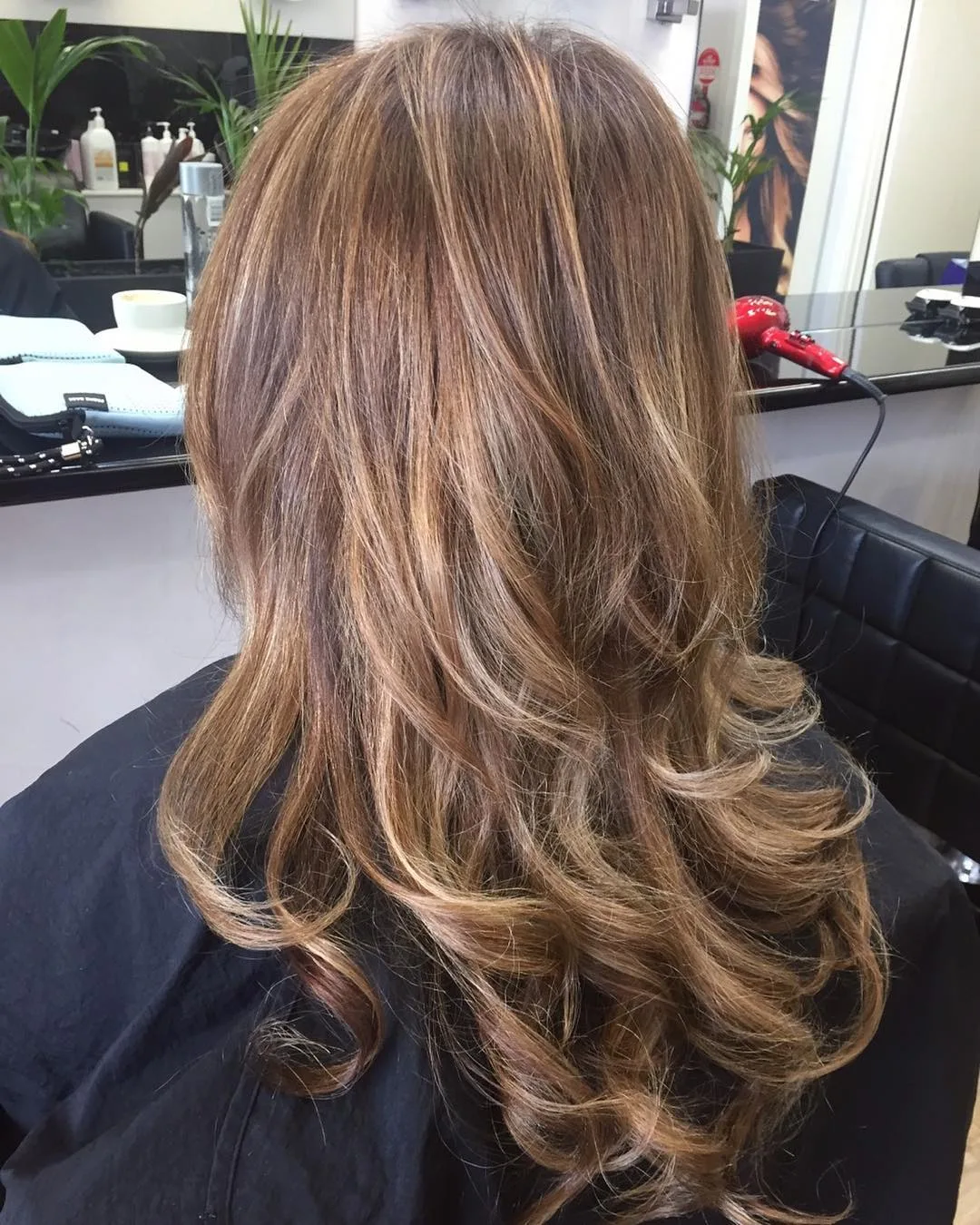 Warm caramel balayage in soft curls, finished at Jolin's Hair Design